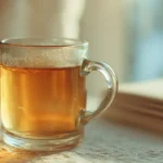 A clear glass mug with warm gelatin drink on counter
